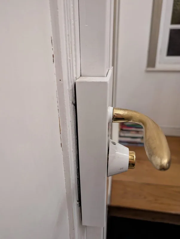 Serrure en applique blanche avec poignée laiton sur porte